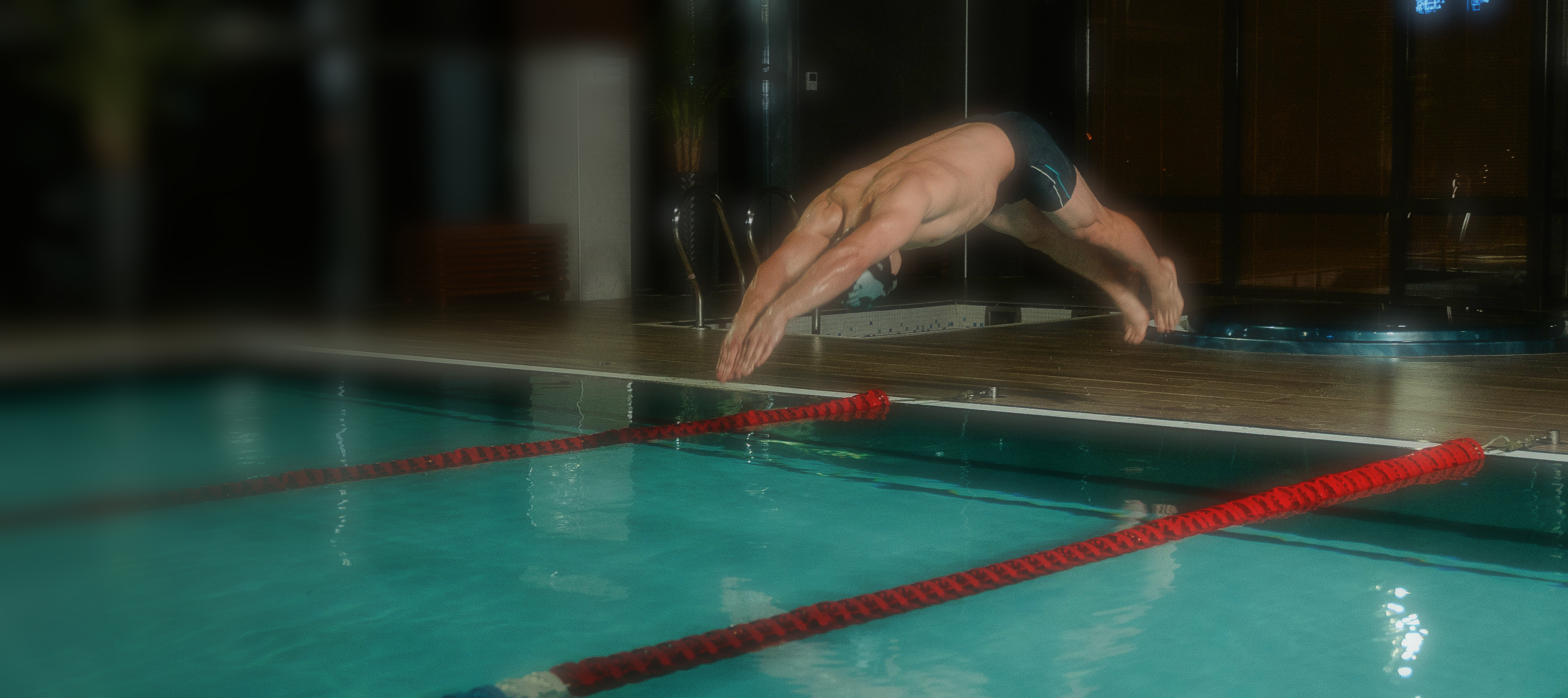 Schwimmer mit Sprung vom Beckenrand